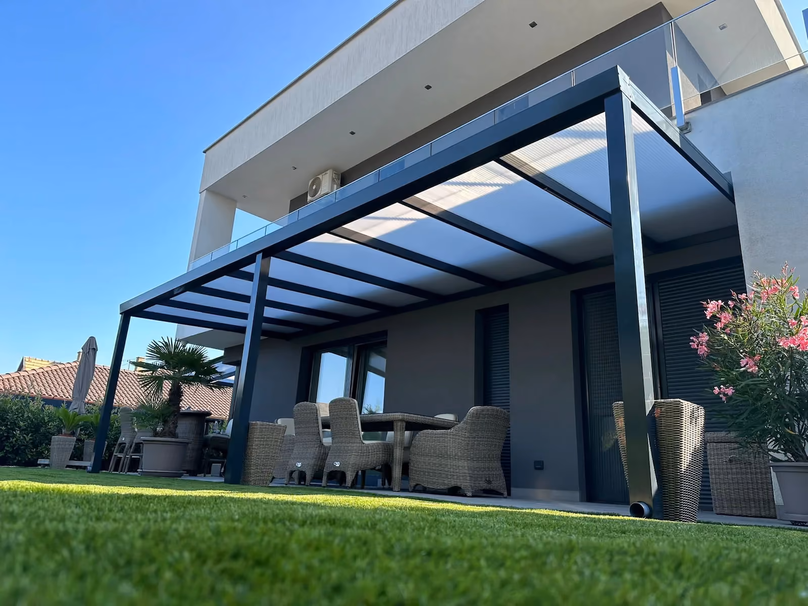 Maßgefertigte Aluminiumpergola neben einer modernen Terrasse montiert