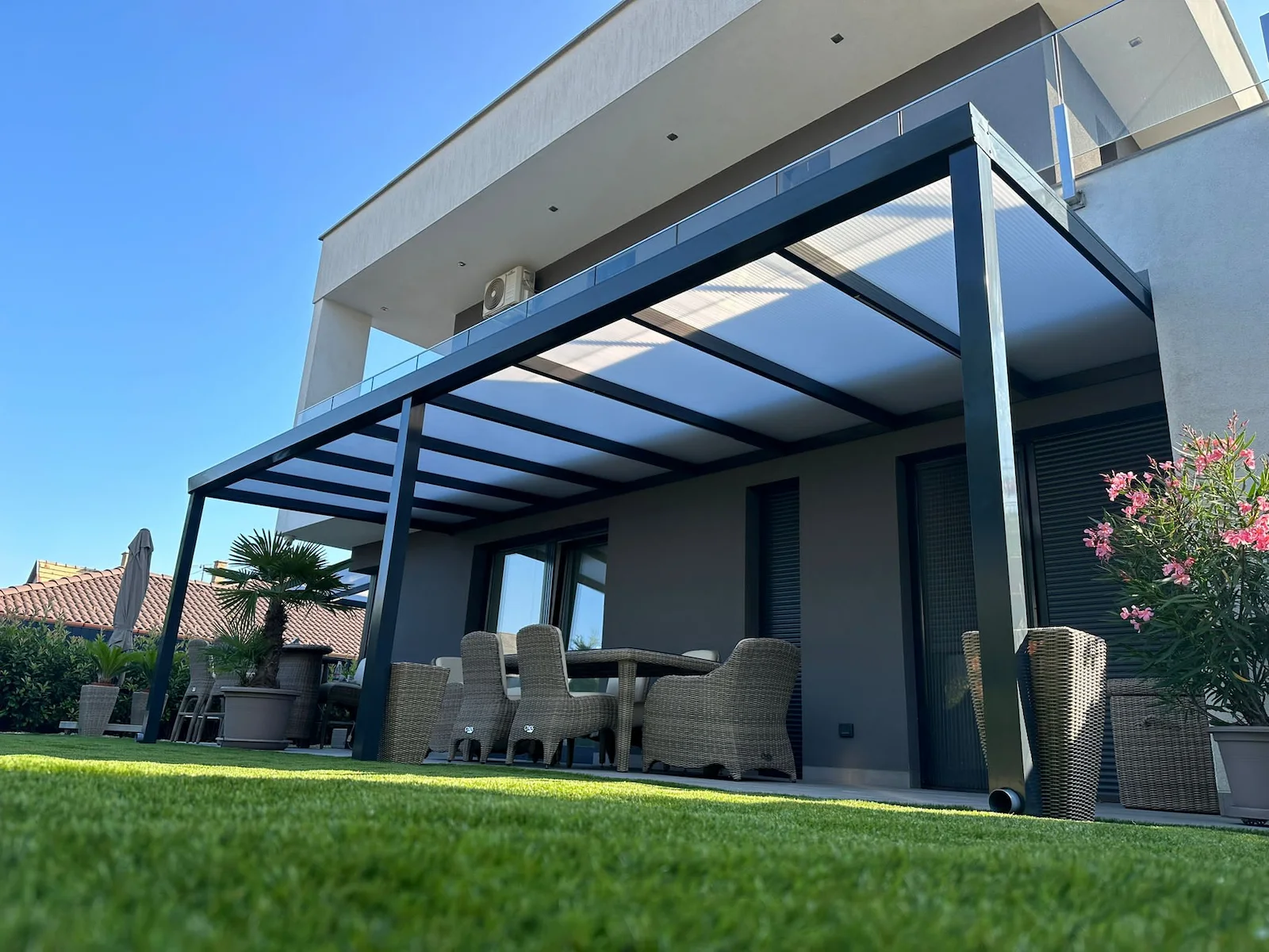 Maßgefertigte Aluminiumpergola neben einer modernen Terrasse montiert