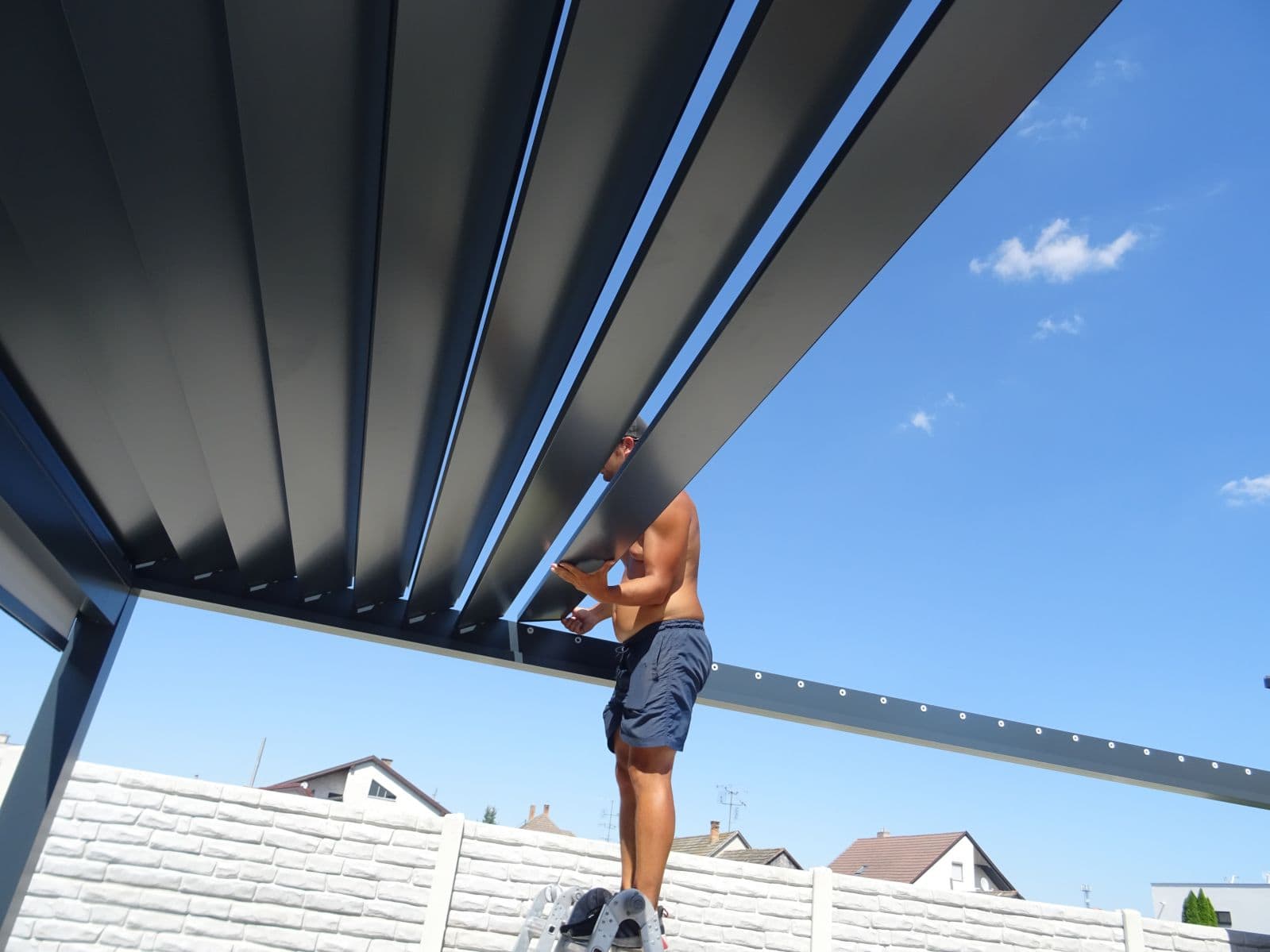 Einsetzen der Aluminiumlamellen einer bioklimatischen Pergola