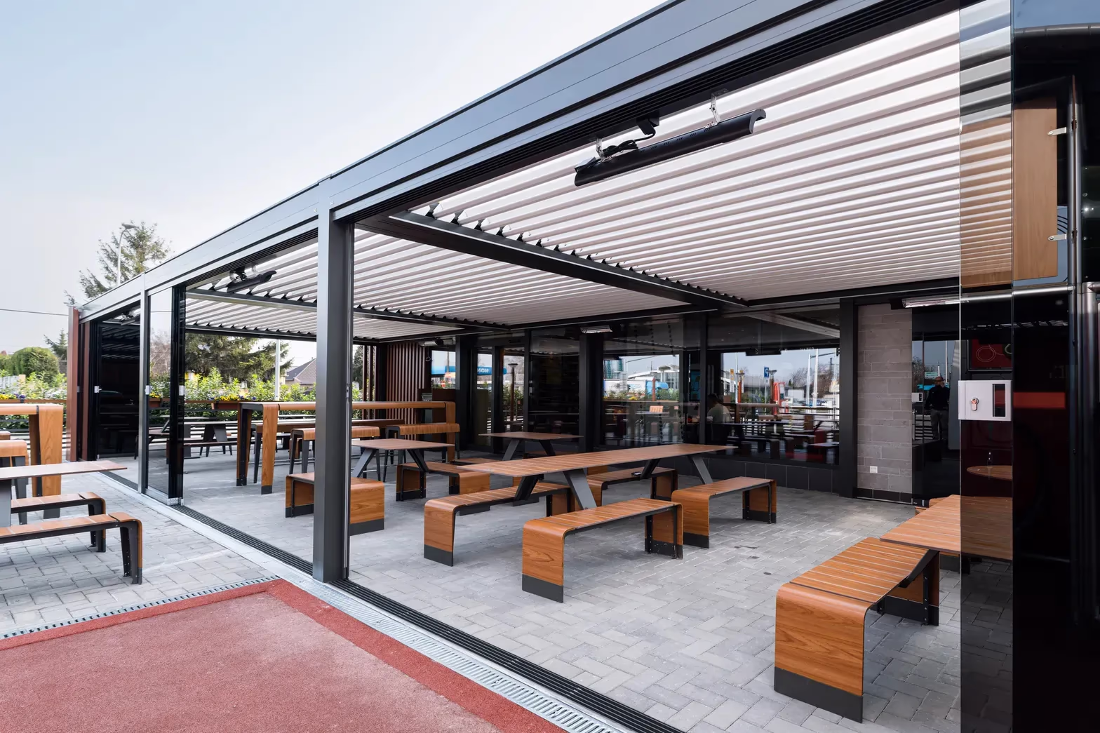 Infrarotheizung, montiert unter dem Dach einer Aluminiumpergola über einer Restaurantterrasse