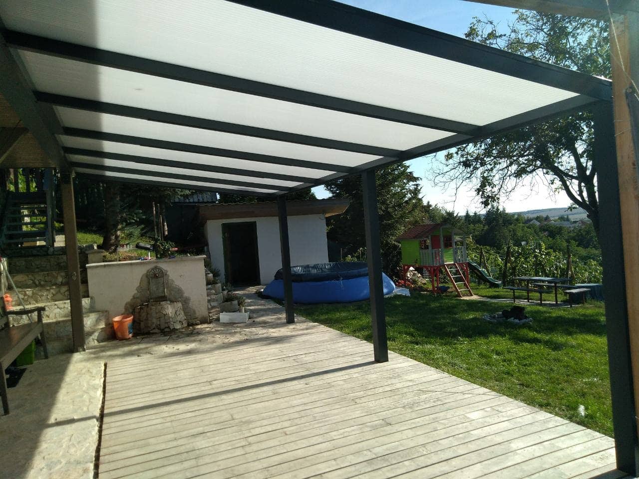 Aluminiumpergola Basic Class neben einem Einfamilienhaus