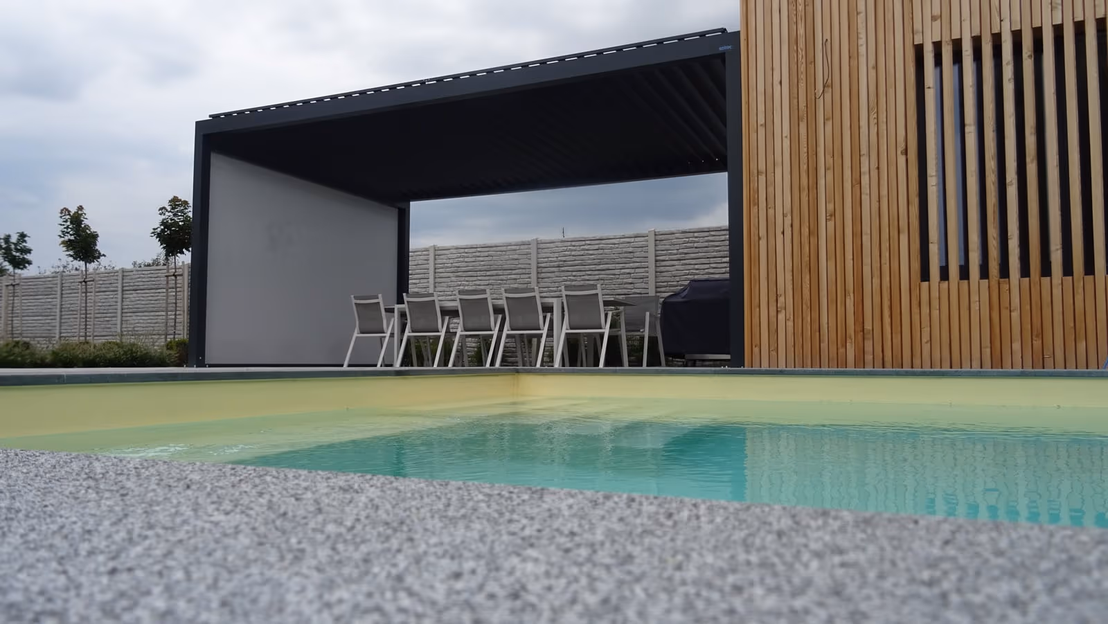 Wohnterrasse unter einer bioklimatischen Aluminiumpergola mit drehbaren Lamellen