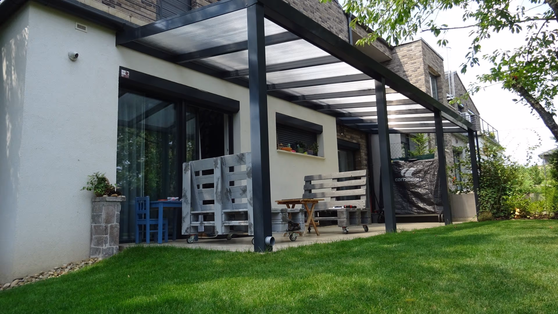 Aluminiumpergola Economic Class am Hauseingang mit Kiesweg