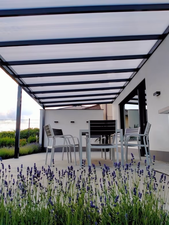 Bogenförmige Aluminiumpergola Economic Class bei einem cremefarbenen Haus