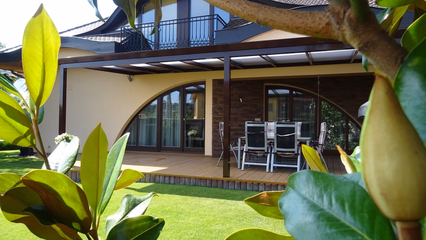 Aluminiumpergola Economic Class an der Haustür mit hängenden Blumentöpfen