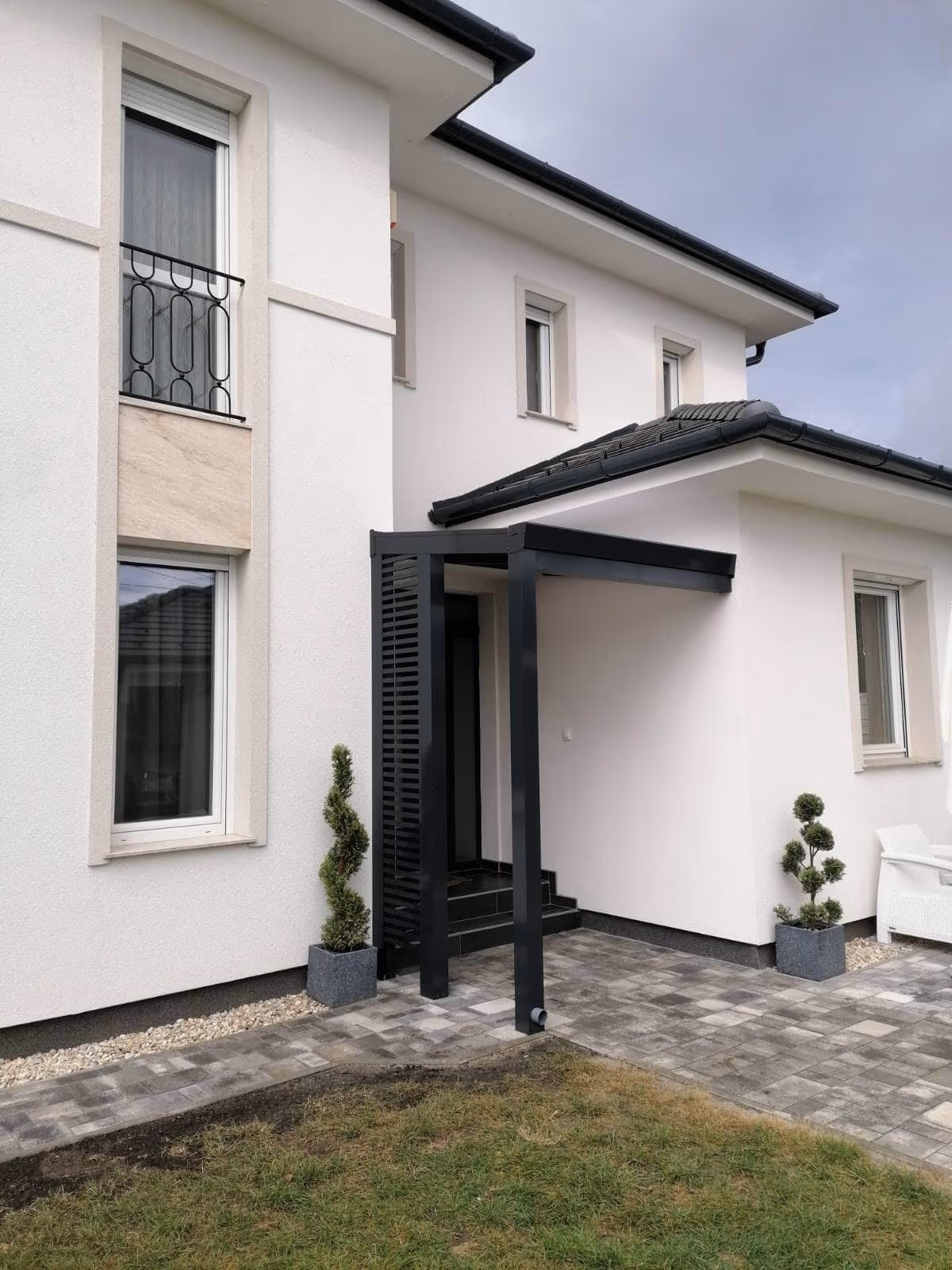 Aluminiumpergola Economic Class bei einem modernen grauen Haus mit Treppe