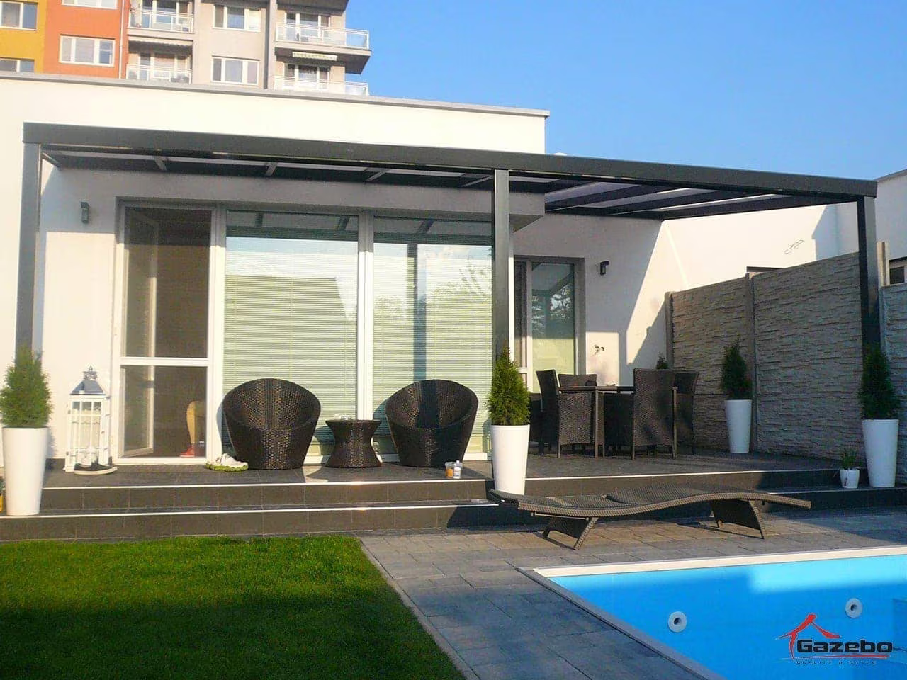 Anthrazitfarbene Aluminiumpergola Economic Class über einer Terrasse am Pool mit Rattanmöbeln