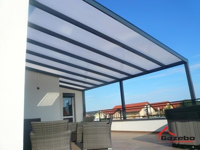 Anthrazitfarbene Aluminiumpergola Economic Class auf einer Dachterrasse mit Rattanmöbeln