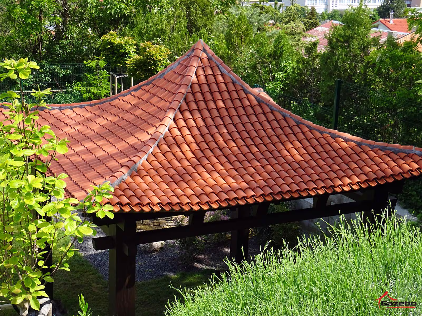 Holzpavillon Hinode mit Keramikdach im Garten eines Einfamilienhauses
