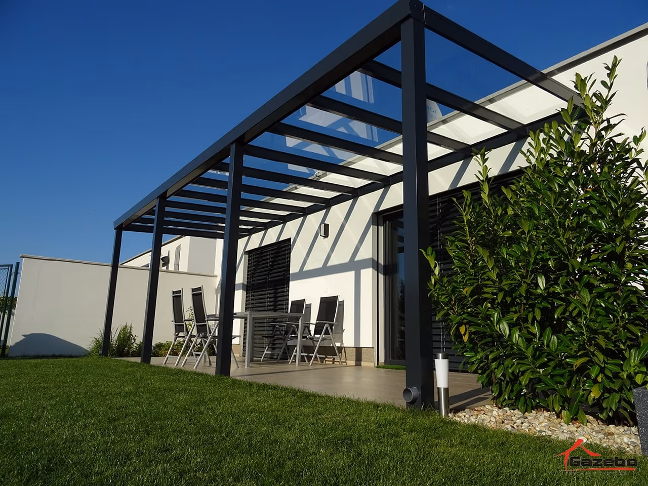 Aluminiumpergola Top Class mit Essplatz bei einem weißen Haus