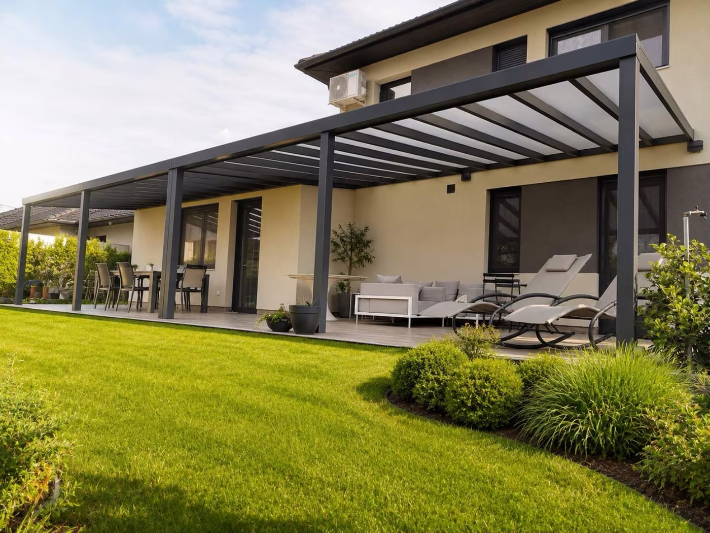 Maßgefertigte Aluminiumpergola Top Class ohne Breitenbegrenzung entlang eines Einfamilienhauses mit Terrassensitzplatz