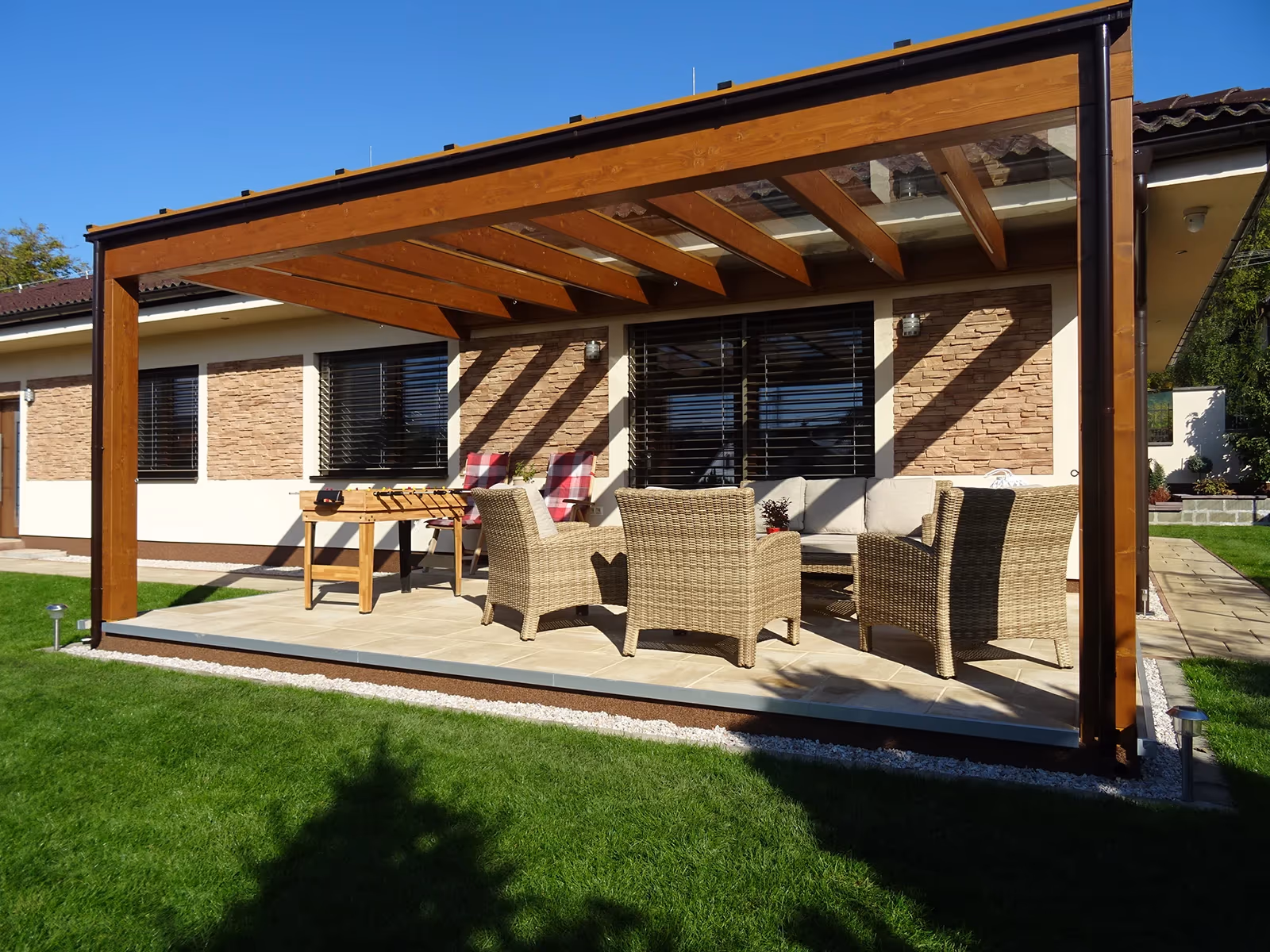 Holzpergola Milano mit Essplatz bei einem Steinhaus