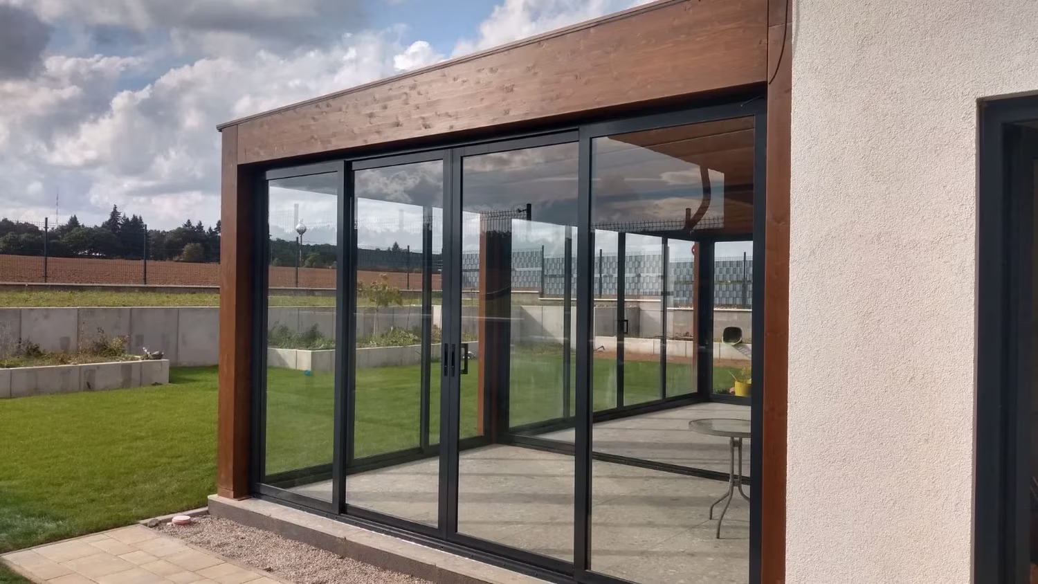 Holzpergola Milano mit verglaster Seitenwand und Schiebetüren
