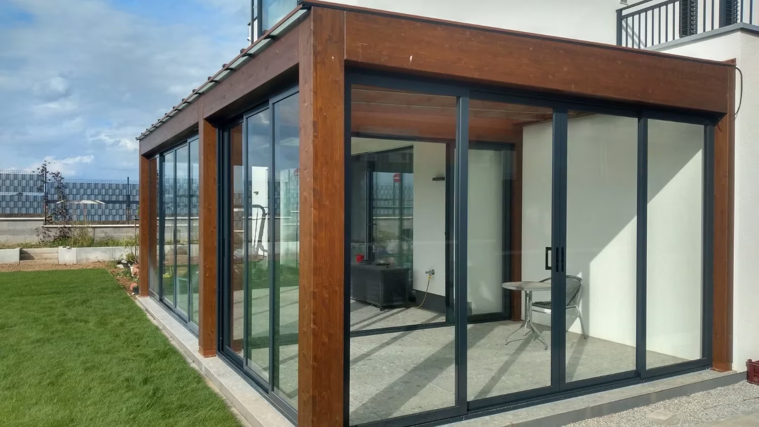 Verglaste Holzpergola Milano als Wohnraum am Haus