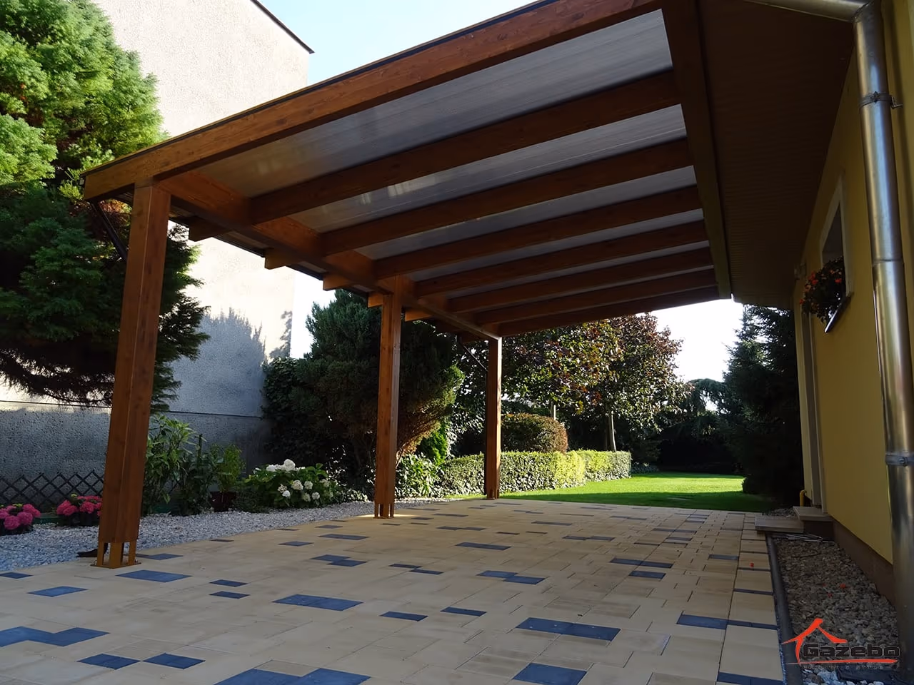 Holzpergola Fenix über der Terrasse eines Einfamilienhauses mit Ziegeldach