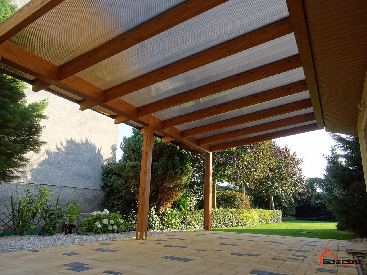 Gemütlich eingerichtete Holzpergola Fenix mit Sitzecke und Blumentöpfen